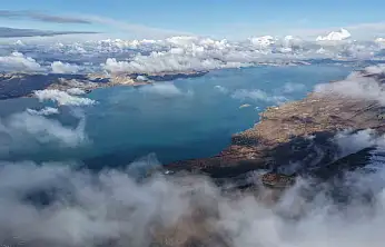 Karla kaplı dağ ve göl, kartpostallık görüntüler sundu.